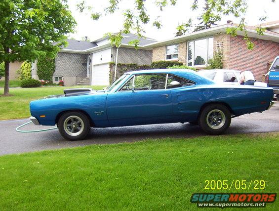 Side view of a blue 1969 Dodge Coronet with a hood scoop and racing wheels