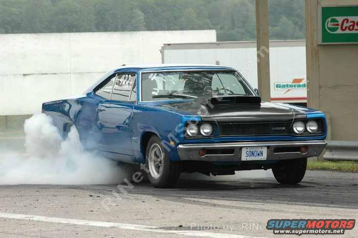 1969 Dodge Coronet doing a burnout, smoke coming from rear tires. License plate reads SONDWN