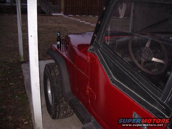 Red Jeep CJ, side view, with a beer bottle on the hood