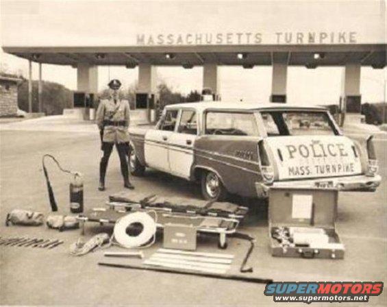 Rear view of a two-tone police station wagon with "POLICE MASS. TURNPIKE" on the tailgate