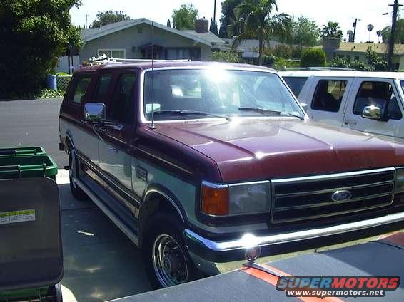 Maroon and silver Ford Bronco SUV parked curbside, front quarter view