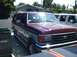 1989 Ford Bronco - A maroon and silver Ford Bronco SUV is parked next to a white vehicle in a residential area.