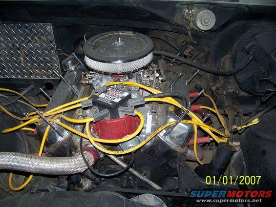 Engine bay with V8 engine, carburetor, and yellow spark plug wires