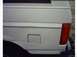 1995 Ford Bronco - The rear of a white SUV shows a dented quarter panel and a fuel filler door.