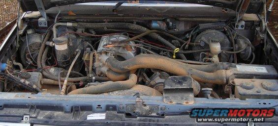 1988 Ford Bronco engine bay with visible hoses, wiring, and engine components