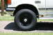 1991 Ford C-350 (Centurion Conversions) - Close-up of the front wheel and fender of a white 1991 Ford C-350 (Centurion Conversions) truck, showing the C350 badge.