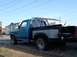 1983 Ford F-150 - This blue pickup truck, likely from the early 1980s, is seen from a 3/4 front angle with a prominent roll bar in the bed.