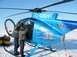 1983 Ford F-150 - A blue helicopter with custom polar bear artwork is parked on a snowy surface, with two individuals near the open door.