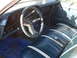 1972 Ford Ranchero - The interior of a classic car features striped blue seats and a dashboard with multiple gauges.