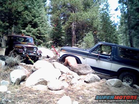 1985 Ford Bronco 3q-front view, blue and white, off-road