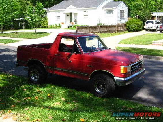 Red 1987 Ford Bronco II parked on a residential street, front quarter view