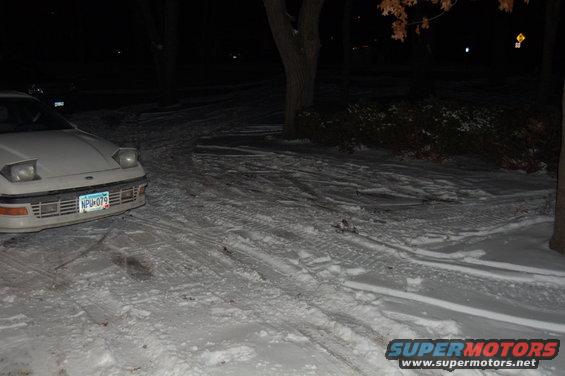 White car with pop-up headlights and license plate NPU-079 in snow
