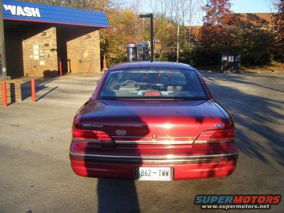 Red 1994 Ford Crown Victoria parked at a car wash, rear view