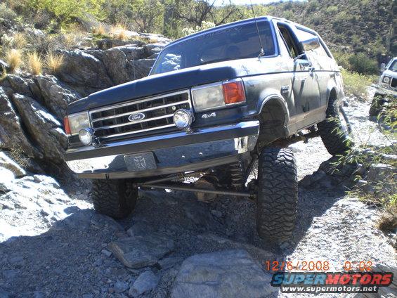 1991 Ford Bronco climbing over rocks on a trail