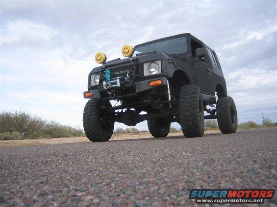 Lifted 1987 Suzuki Samurai with smiley face auxiliary lights and a winch