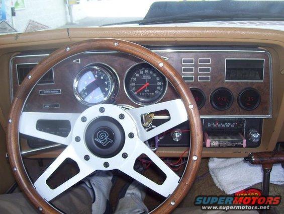 car interior with wood grain dash, Grant GT steering wheel, and aftermarket gauges