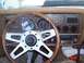 1977 Ford Mustang II - The interior of a car features a wood-grain dashboard, a Grant GT steering wheel, and multiple gauges.
