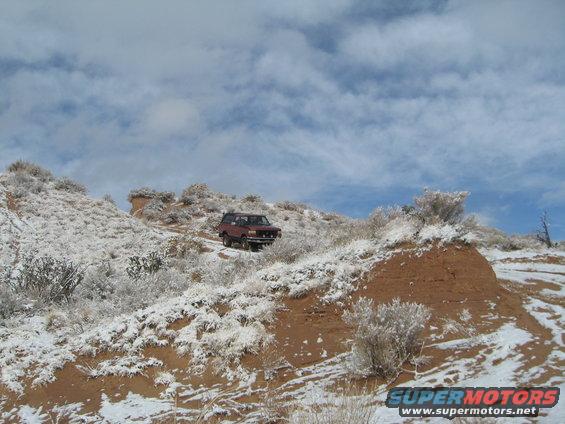 Red 1993 Ford Bronco on snowy mountain road