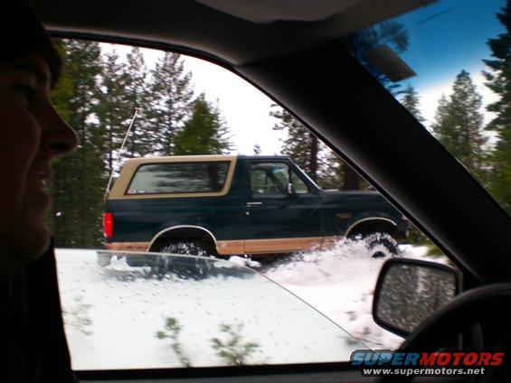 1995 Ford Bronco driving through snow and water.