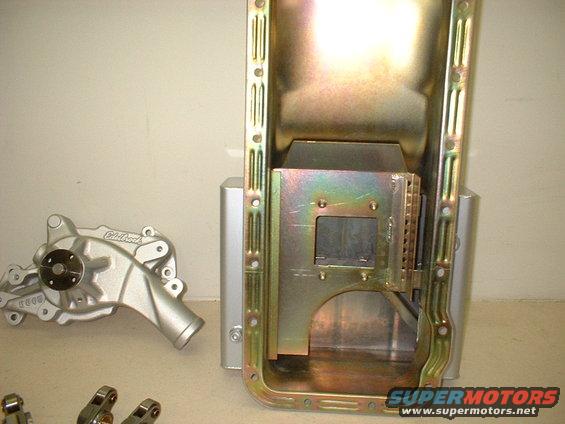 Engine oil pan and water pump parts on a table