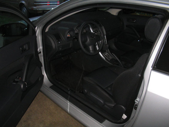 Interior of a silver 2005 Scion tC showing dashboard, steering wheel, and seats