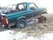 1996 Ford Bronco - 1996 Ford Bronco with aftermarket roll cage and lifted suspension navigating snowy terrain.