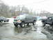 2000 Ford Excursion - A lifted Ford Excursion is parked in a snowy lot next to other vehicles.