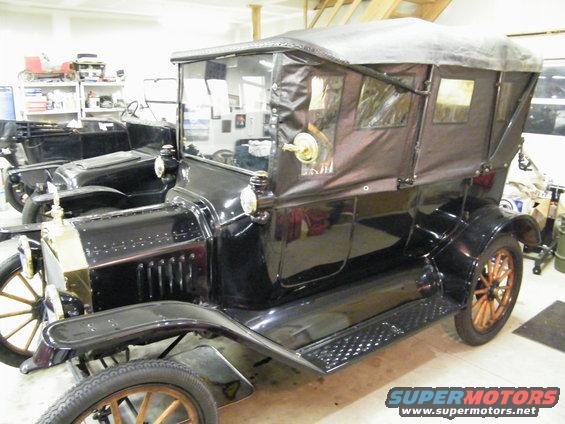 Black 1915 Ford Model T touring car with a soft top, seen from the front three-quarter angle