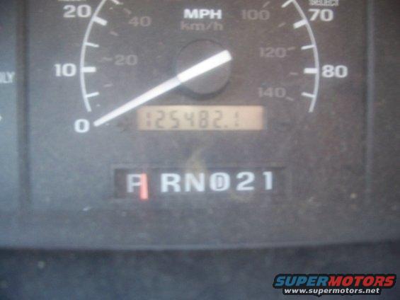 Close-up of a vehicle's dashboard showing the odometer reading 125482.1 and the gear selector in 'R' (Reverse)