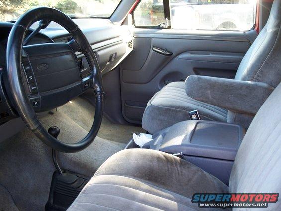 Gray fabric seats and dashboard of a truck interior, with a black steering wheel and center console