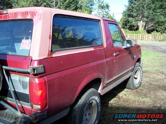 Red SUV with removable top, rear quarter view