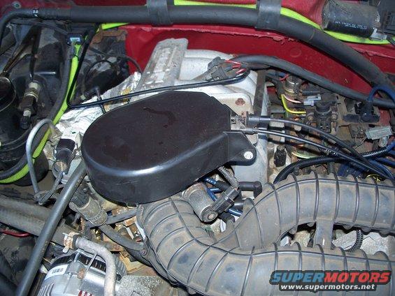 Engine bay with air intake hose and black cover over engine components. Supermotors.net logo visible