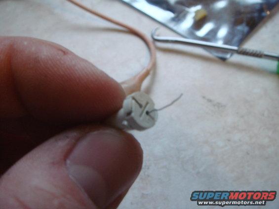 Unwind the wires and pull the bulb straight out of the holder