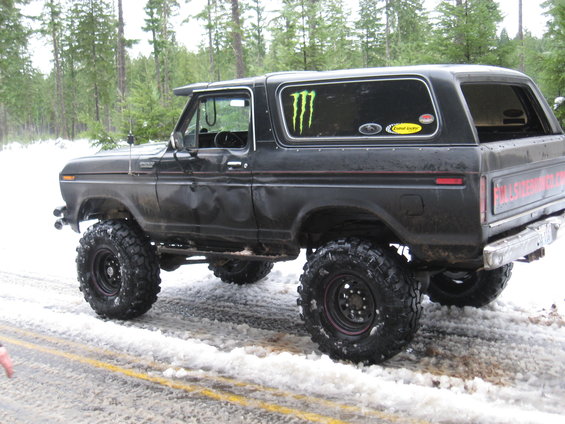 Lifted black Ford Bronco with Monster Energy sticker on snowy road