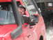 1989 Ford Bronco - A man in a red off-road vehicle with a snorkel looks out the window while another vehicle is behind him.