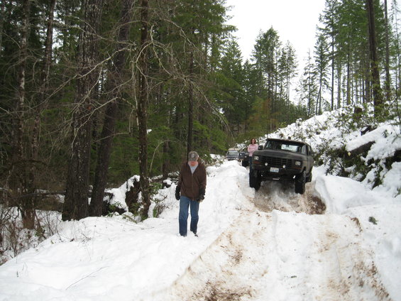 Black Ford Bronco driving on a snow-covered dirt road