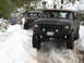 1989 Ford Bronco - Several modified SUVs navigate a snowy trail, with the lead vehicle displaying a license plate.