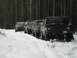 1989 Ford Bronco - A line of SUVs, including a 1980 Ford Bronco, navigate a snowy forest road.