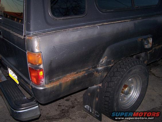 1988 Toyota Pickup/SR5 rear corner showing rust on the lower body panel and a camper shell