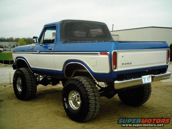 lifted blue and white Ford pickup with soft top