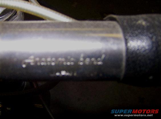 Close-up of a metal pipe with stamped text that reads 'Anatcmic bend'