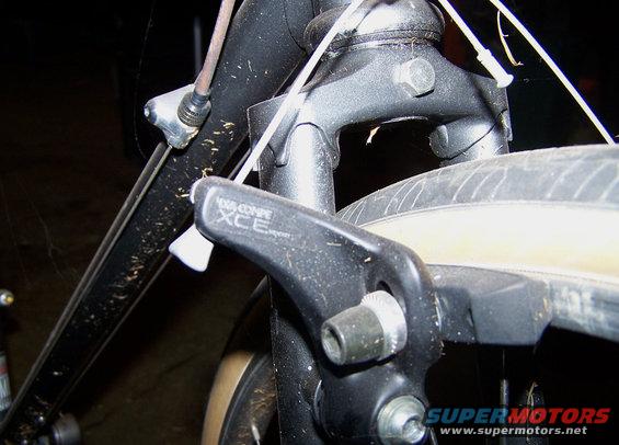 Close-up of a bicycle's front brake caliper, labeled 'DIA-COMPE XCE'