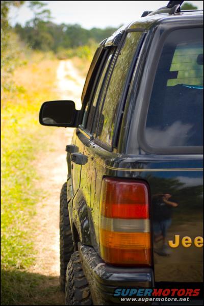 Black Jeep Grand Cherokee rear quarter panel with 'Jee' visible on the tailgate