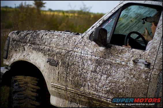 Mud-covered 1996 Ford F-150, driver visible through window