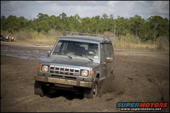 Gray Mitsubishi Montero driving through mud
