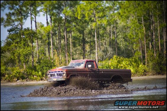 Brown 1977 Ford F-150 driving through mud