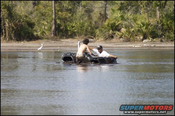 Two guys in an ATV stuck in the mud and water