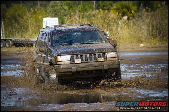 Black Jeep Grand Cherokee driving through mud