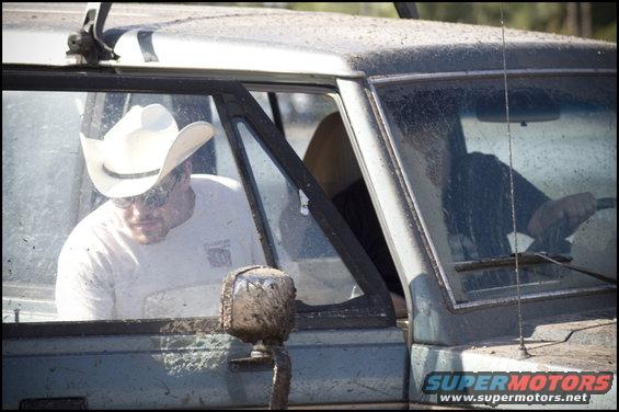 Dirty vehicle interior with a man in a white cowboy hat and sunglasses, and another man driving
