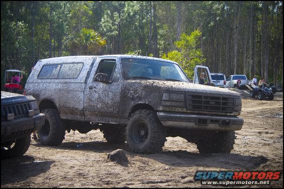 Mud-covered 1996 Ford F-150 with camper shell, 3/4 front view